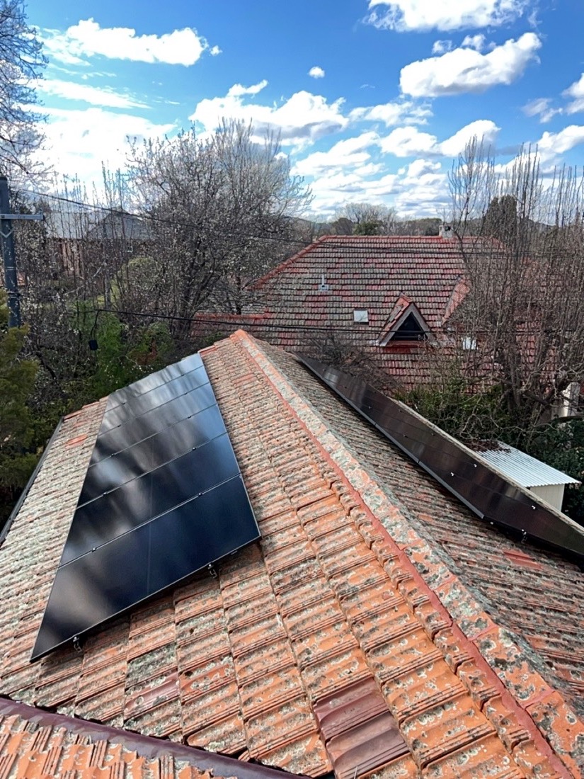 Black Enphase solar panels on a terracotta tile roof in Barton