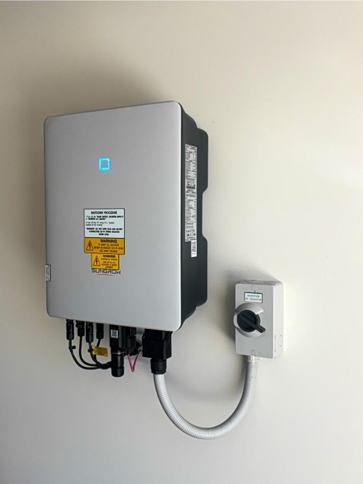 Sungrow solar inverter and AC isolator mounted on a garage wall