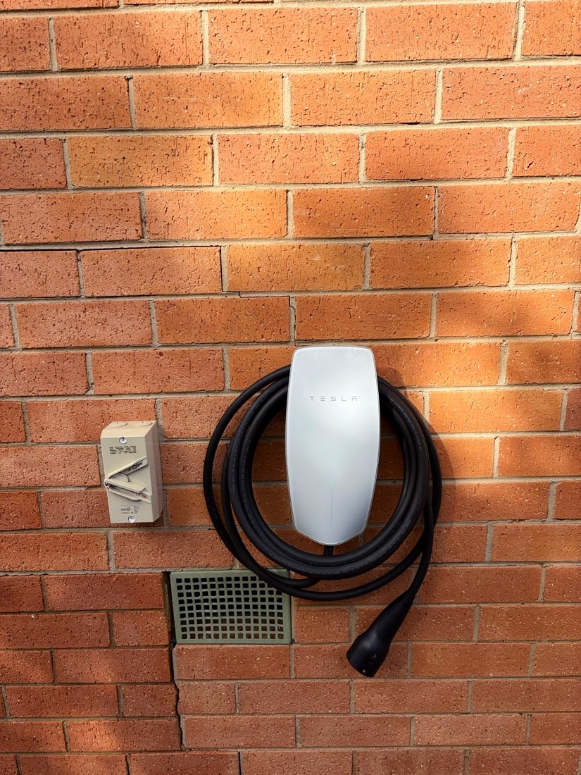 Tesla Wall Connector mounted on a brick wall with isolator in Kambah