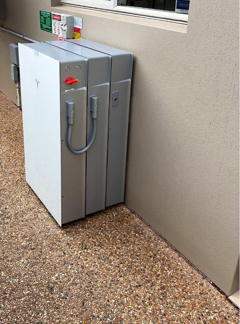 Tesla Powerwall 3 with two Expansion Packs along a rendered side wall